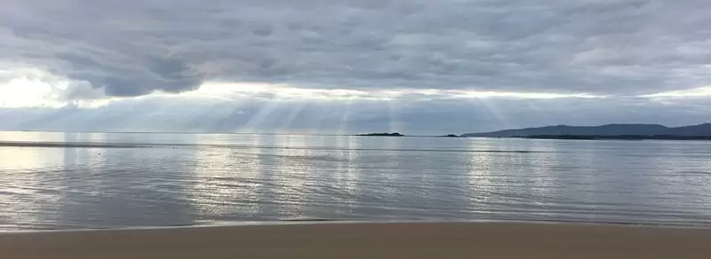 Sunrays through clouds at the beach